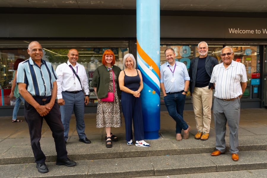 Group of people standing by a painted pillar