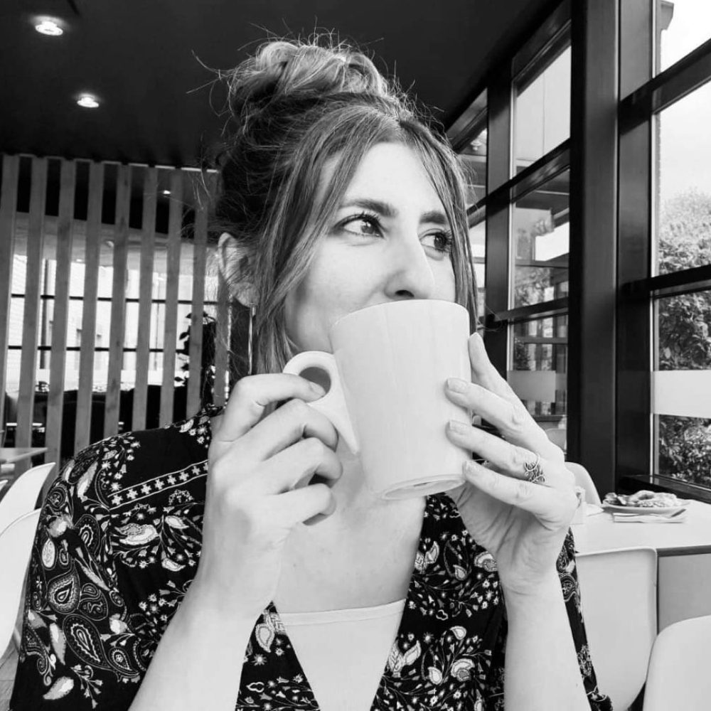 A woman drinking out of a mug