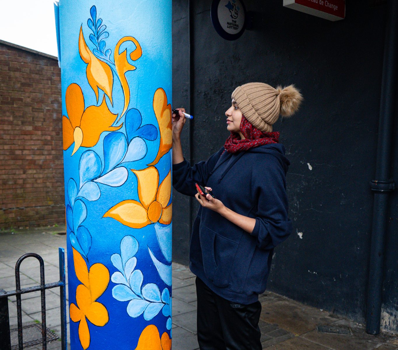 Woman painting a pillar outside