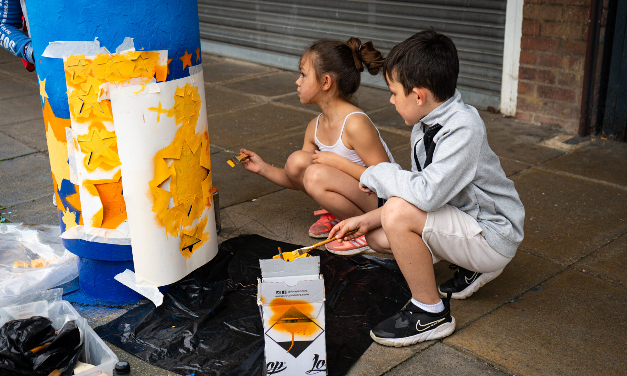 Two children painting outside