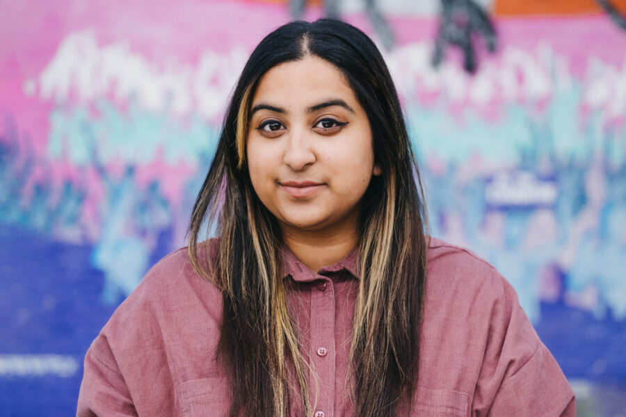 A woman standing in front of a colourful background