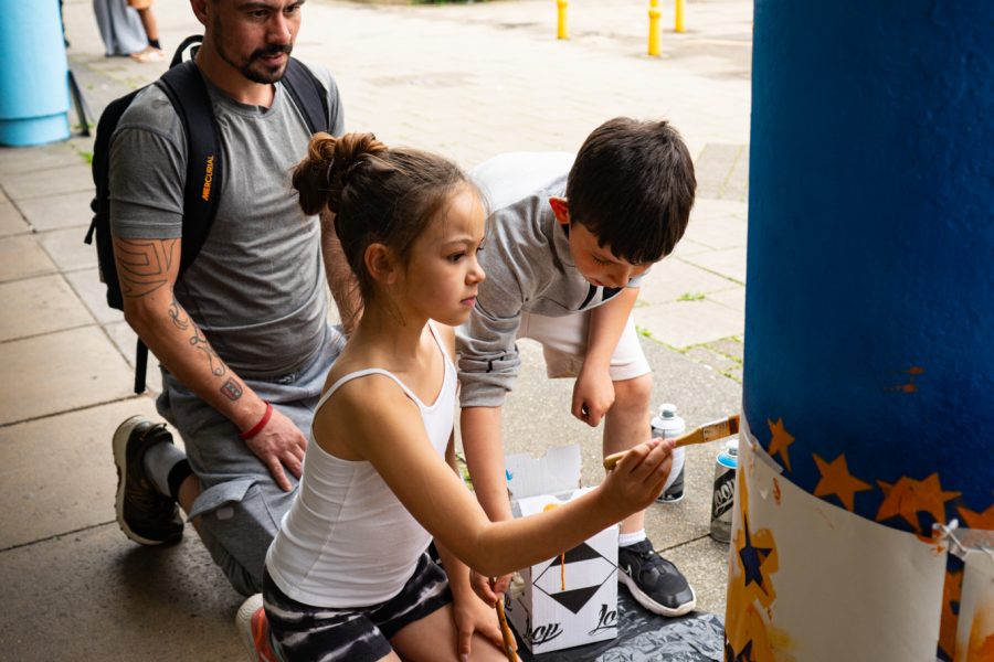 Group of people painting a pillar