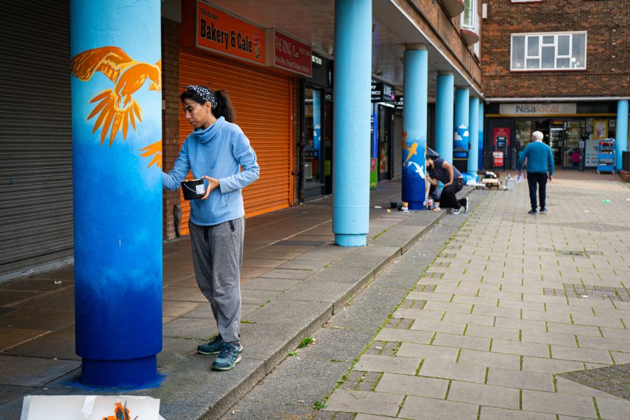 People painting a series of pillars