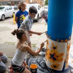 People painting a pillar