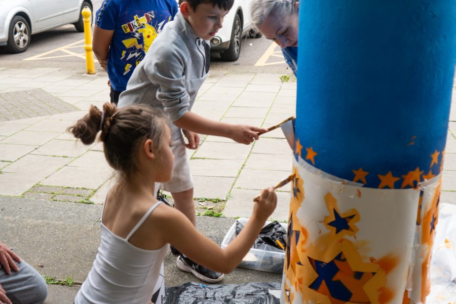 People painting a pillar