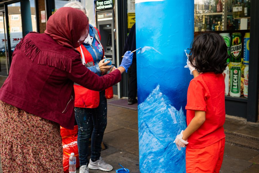 People painting a pillar