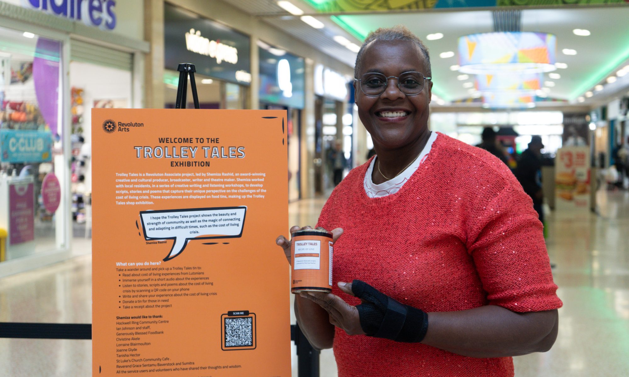 A smiling woman holding a can of food