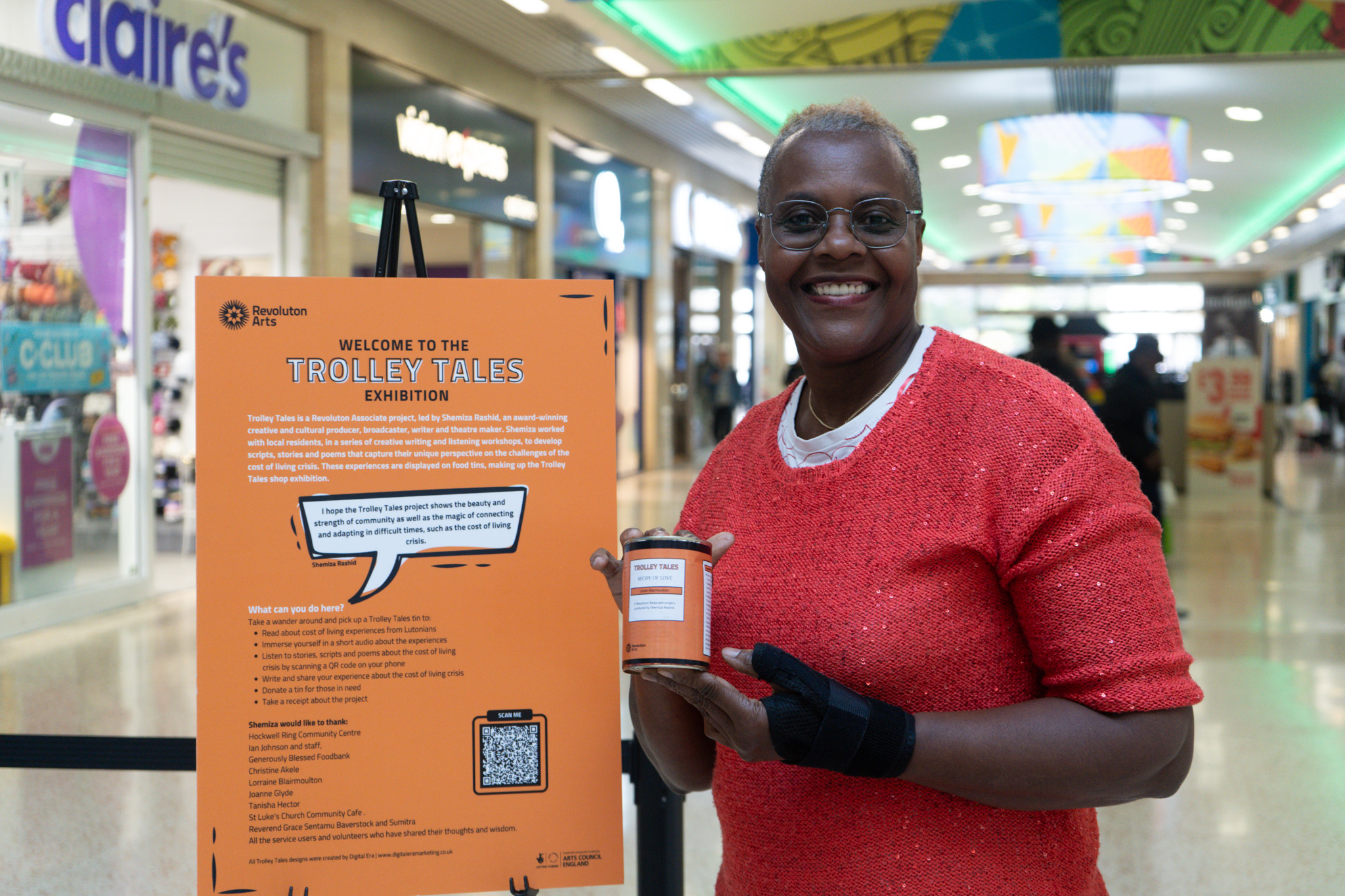 A smiling woman holding a can of food