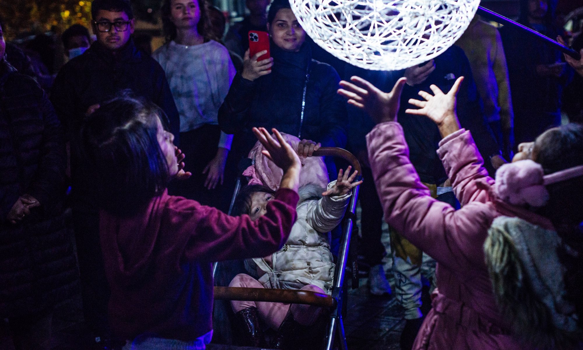 People reaching for illuminated globe