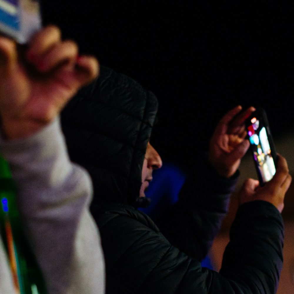 Two men taking pictures on their phones