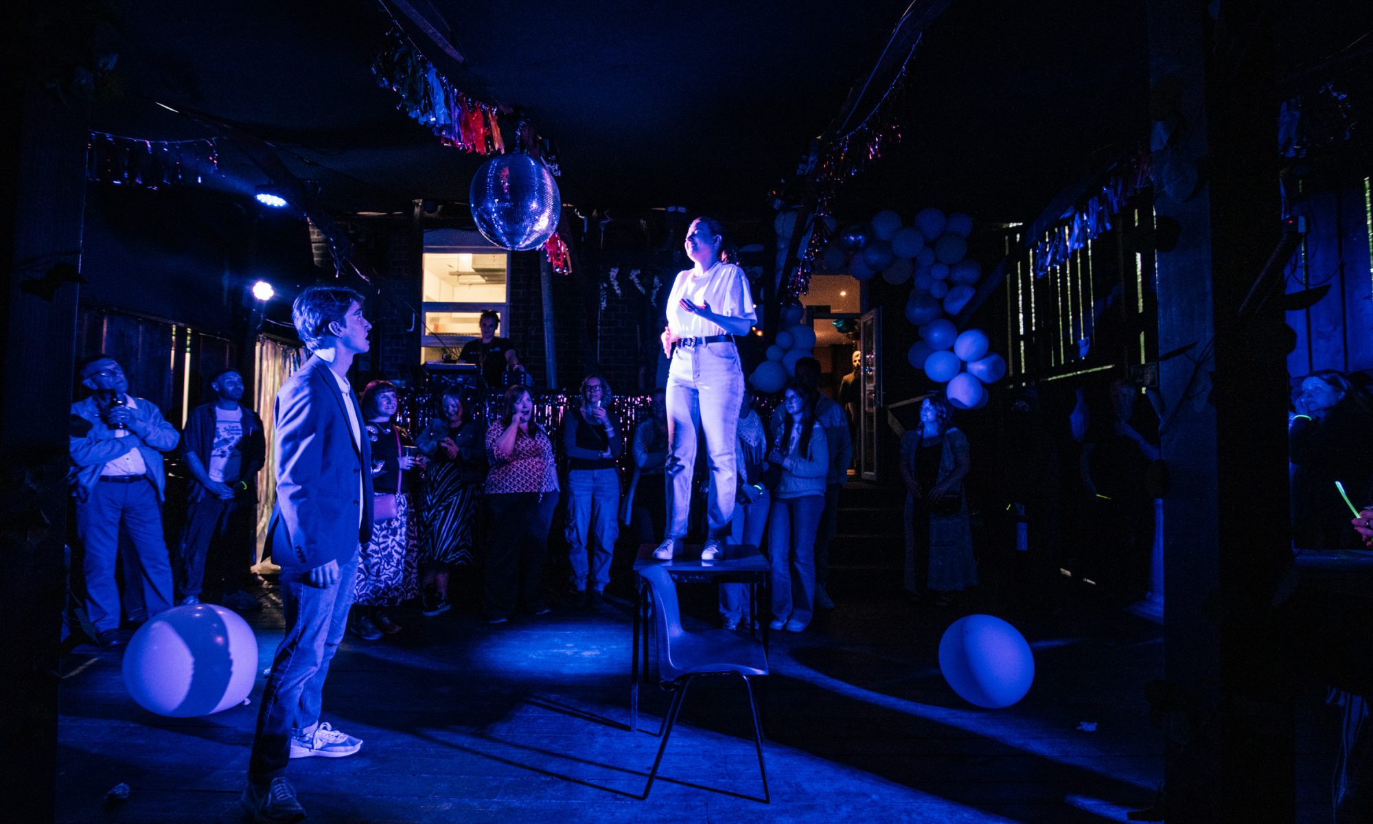 Performer standing on a table surrounded by a crowd