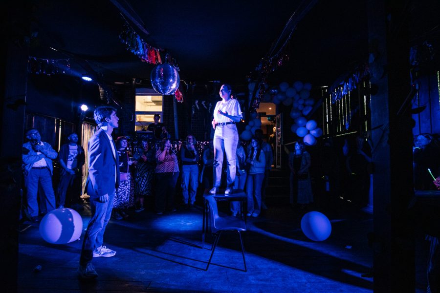 Performer standing on a table surrounded by a crowd