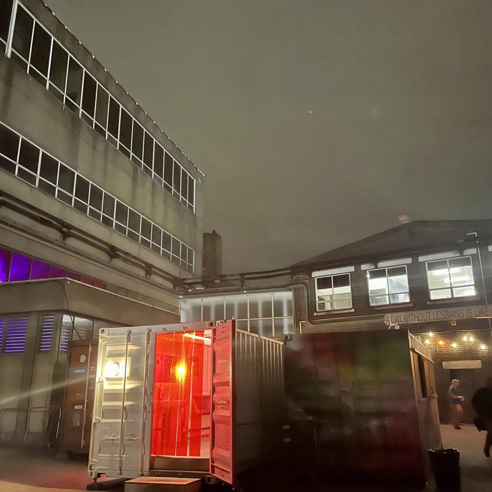 A night time shot of industrial buildings behind an illuminated porta cabin