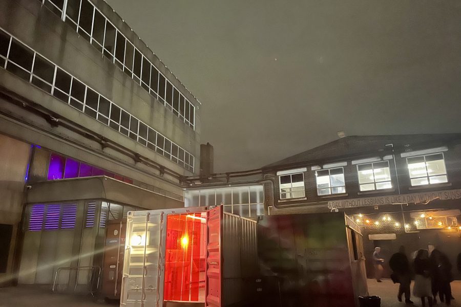 A night time shot of industrial buildings behind an illuminated porta cabin